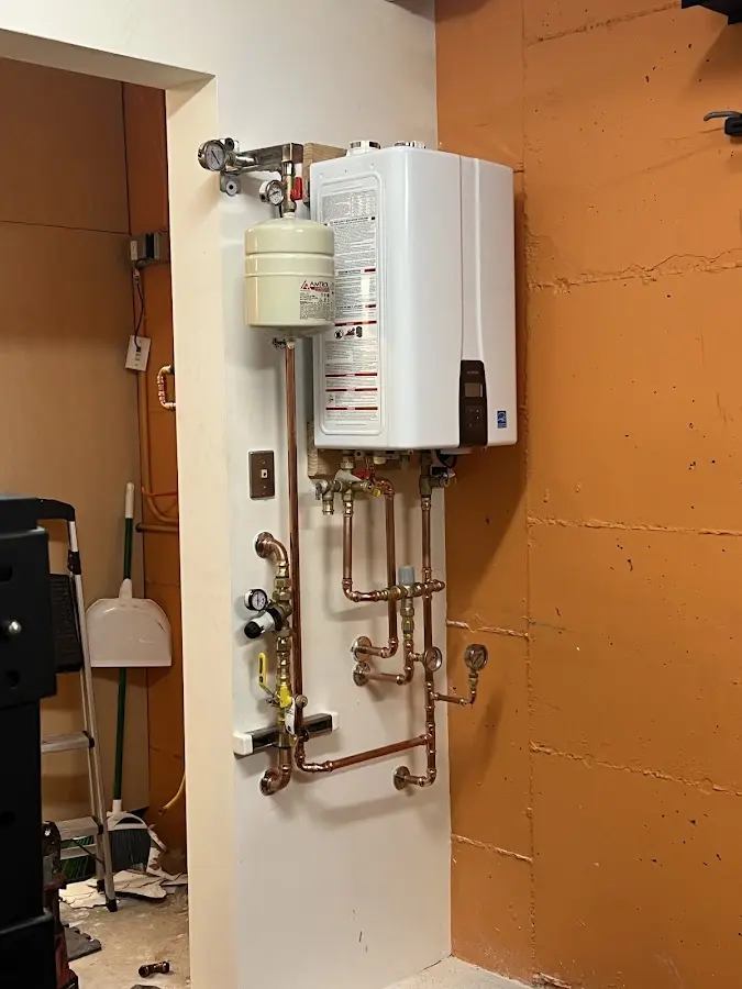 Plumbing technician inspecting water heater connections in Thibodaux